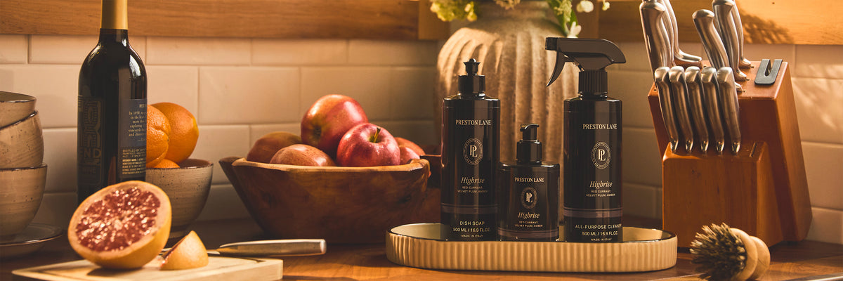 Preston Lane luxury home care products on a kitchen counter with fresh fruit and flowers