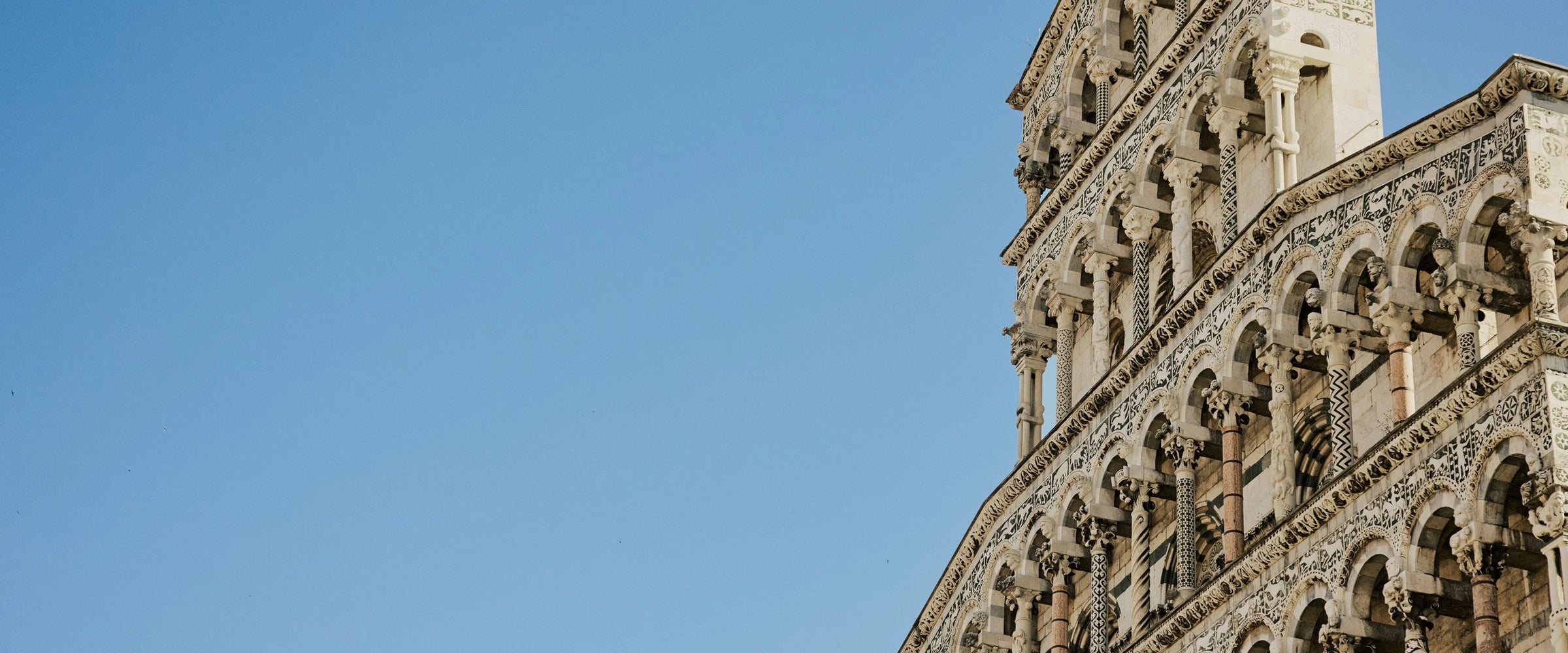Architectural detail of a building with intricate designs against a clear blue sky